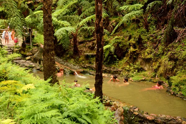 Caldeira Velha forest setting — laurel canopy, mineral-stained pool edges, and the geothermal waterfall in the heart of the Serra de Água de Pau, São Miguel, Azores