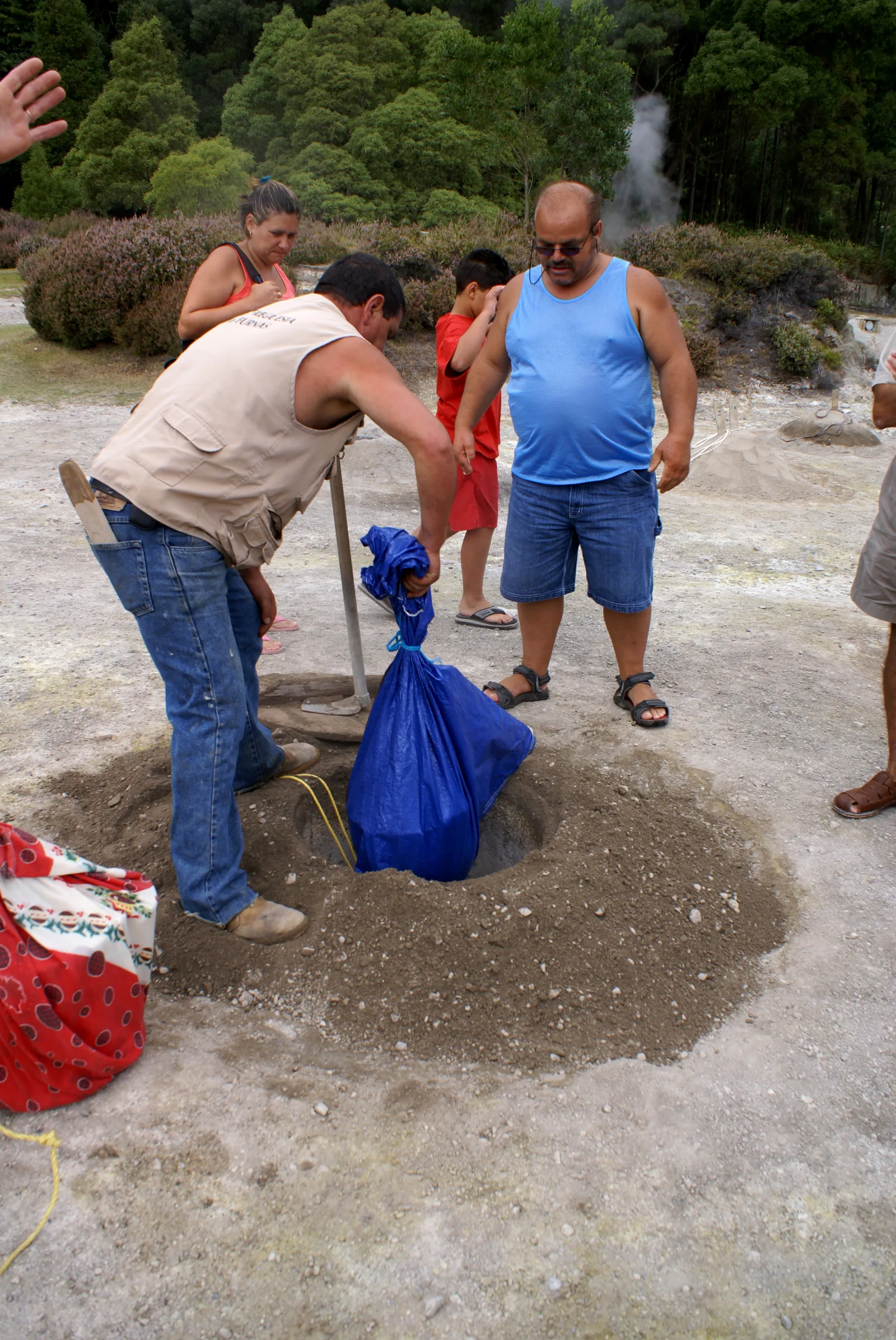 Cozido das Furnas pots being unearthed from the volcanic caldeiras on the shore of Lagoa das Furnas, São Miguel — the moment the stew comes out of the ground at midday