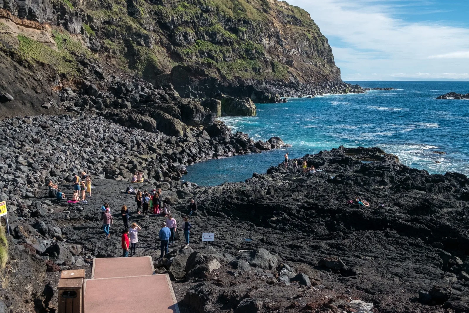 The geothermal sea pool at Ponta da Ferraria — warm spring water meeting the Atlantic against the black volcanic cliffs on the west coast of São Miguel, Azores