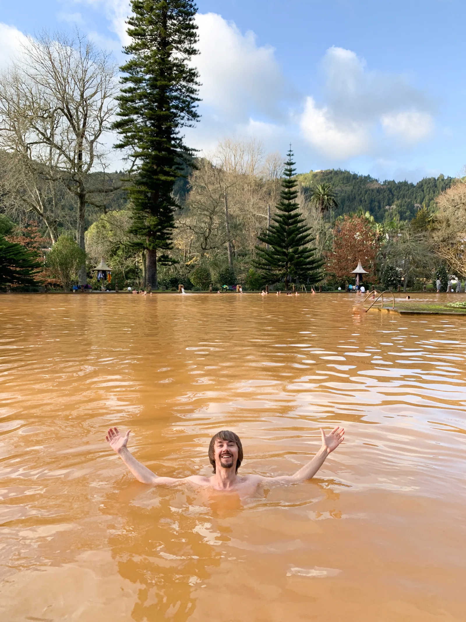 Visitor swimming in the iron-rich thermal pool at Terra Nostra Park, Furnas — São Miguel, Azores